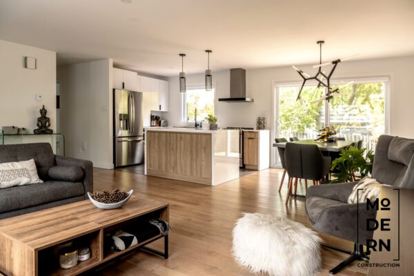 Salon moderne avec cuisine ouverte et îlot central.