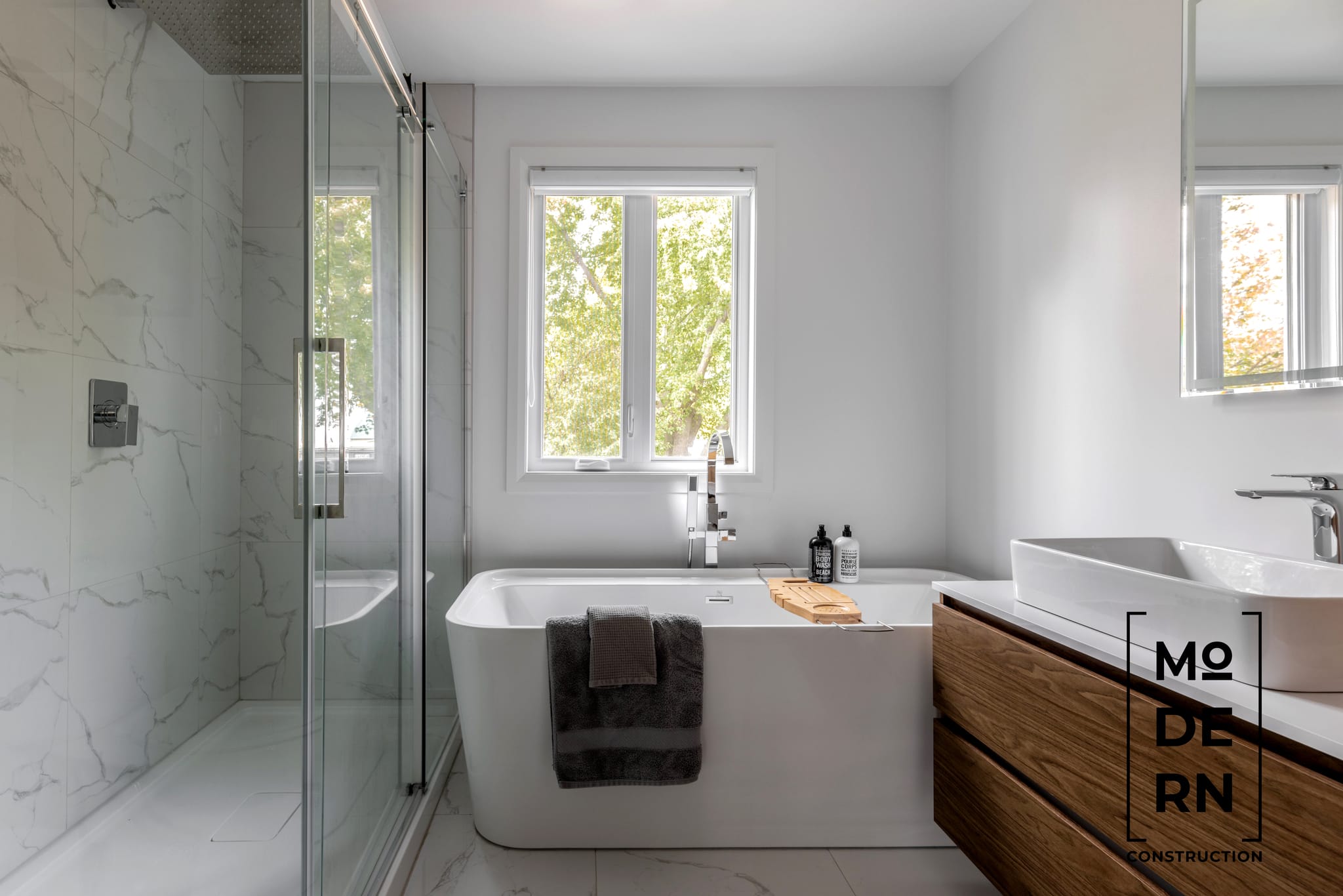 Salle de bain moderne avec douche et baignoire.