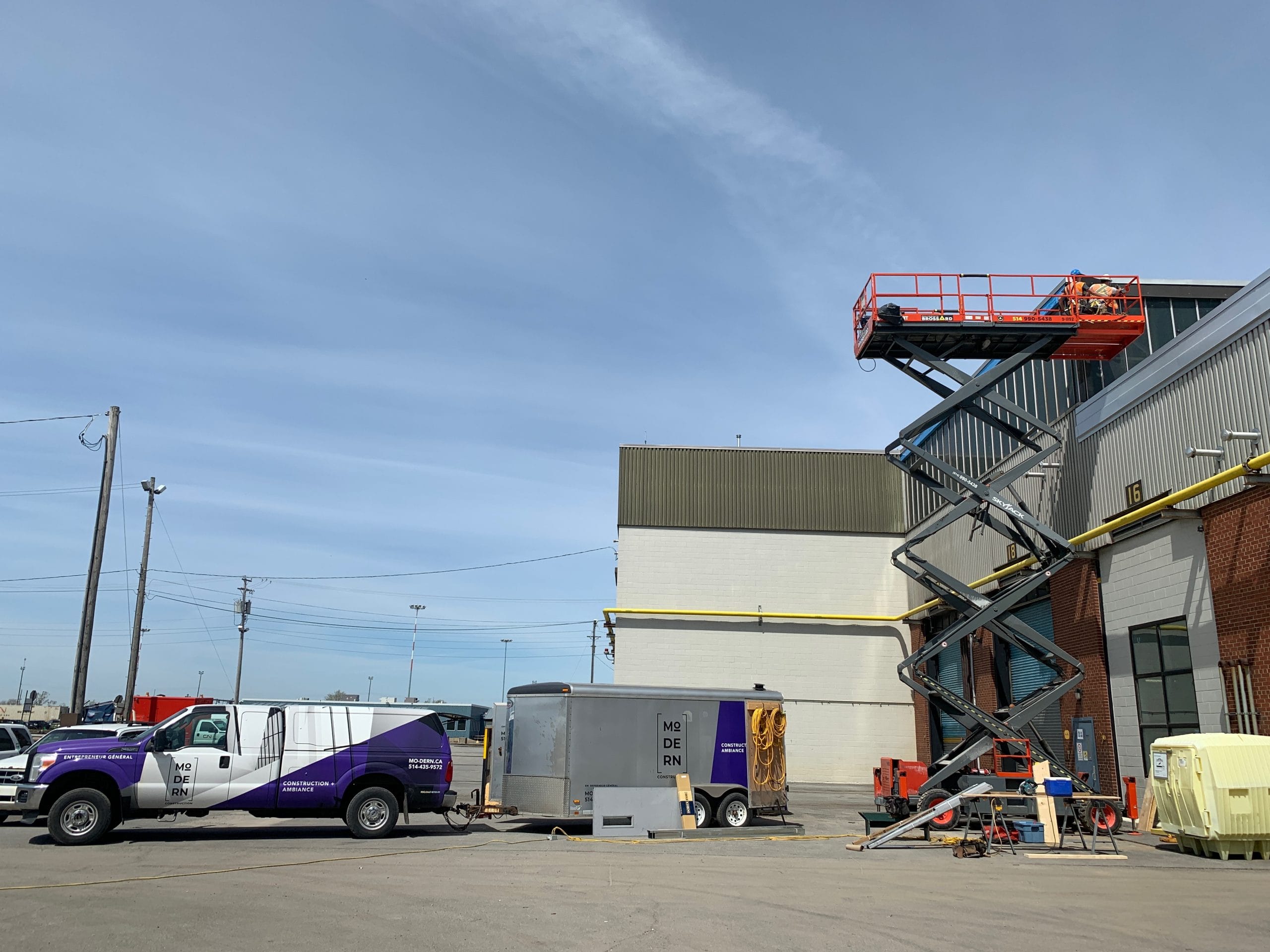 Travailleurs utilisant une nacelle élévatrice sur un chantier.