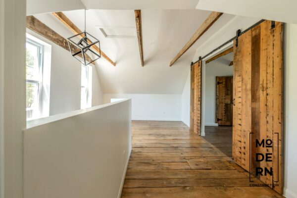 Intérieur moderne avec poutres apparentes et portes coulissantes.