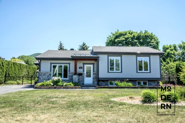 Maison moderne avec jardin bien entretenu.