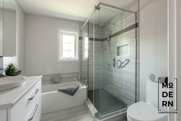 Salle de bain moderne avec douche en verre.