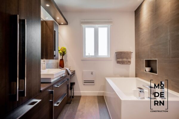 Salle de bain moderne avec baignoire et lavabo.