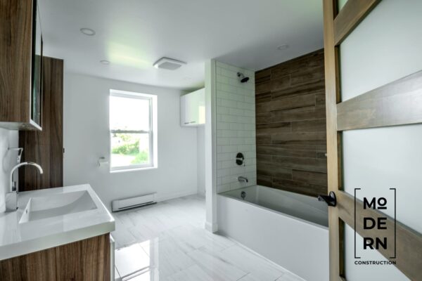 Salle de bain moderne avec baignoire et carrelage.