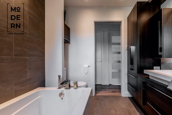 Salle de bain moderne avec baignoire et portes en bois.