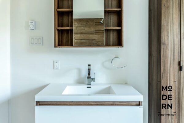 Salle de bain moderne avec lavabo et miroir.