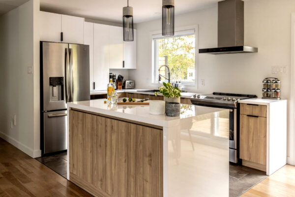 Cuisine moderne avec îlot central bois et inox.