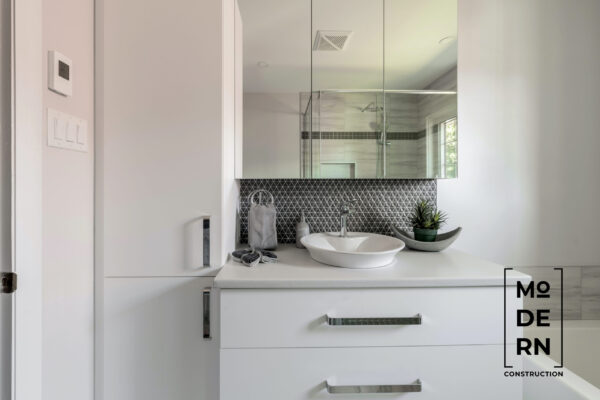 Salle de bain moderne avec lavabo design et miroir.