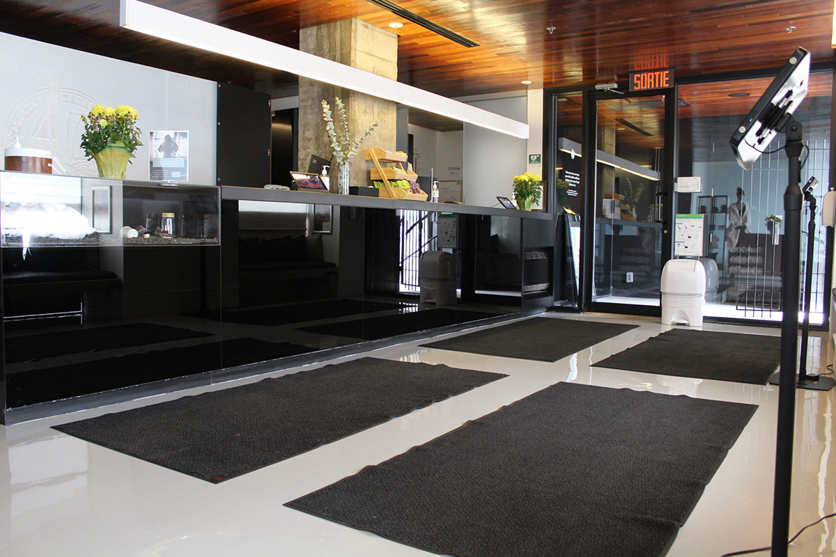 Hall d'entrée avec tapis noirs, comptoir moderne.
