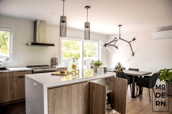 Cuisine moderne avec îlot central et lumière naturelle.