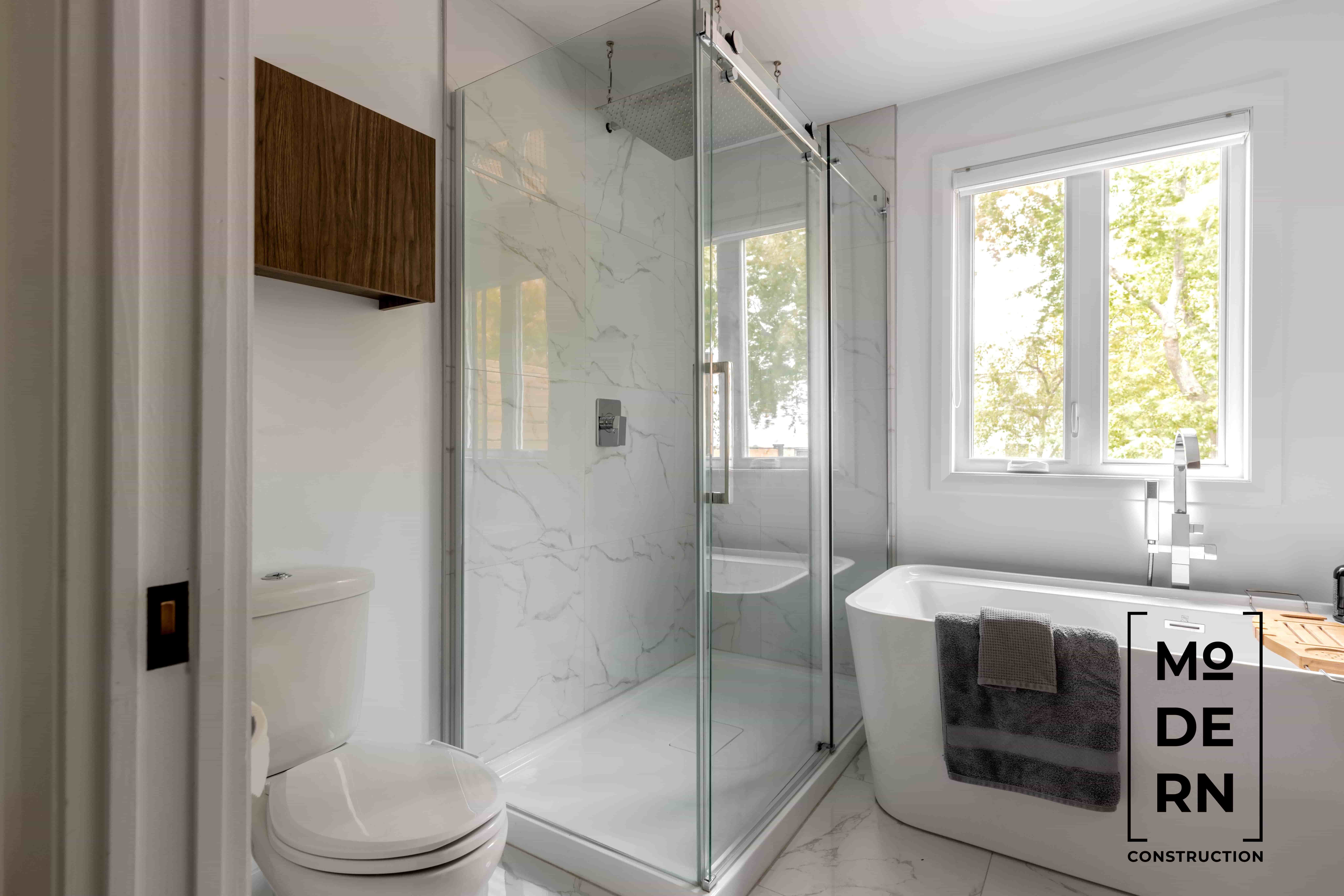 Salle de bain moderne avec douche et baignoire.