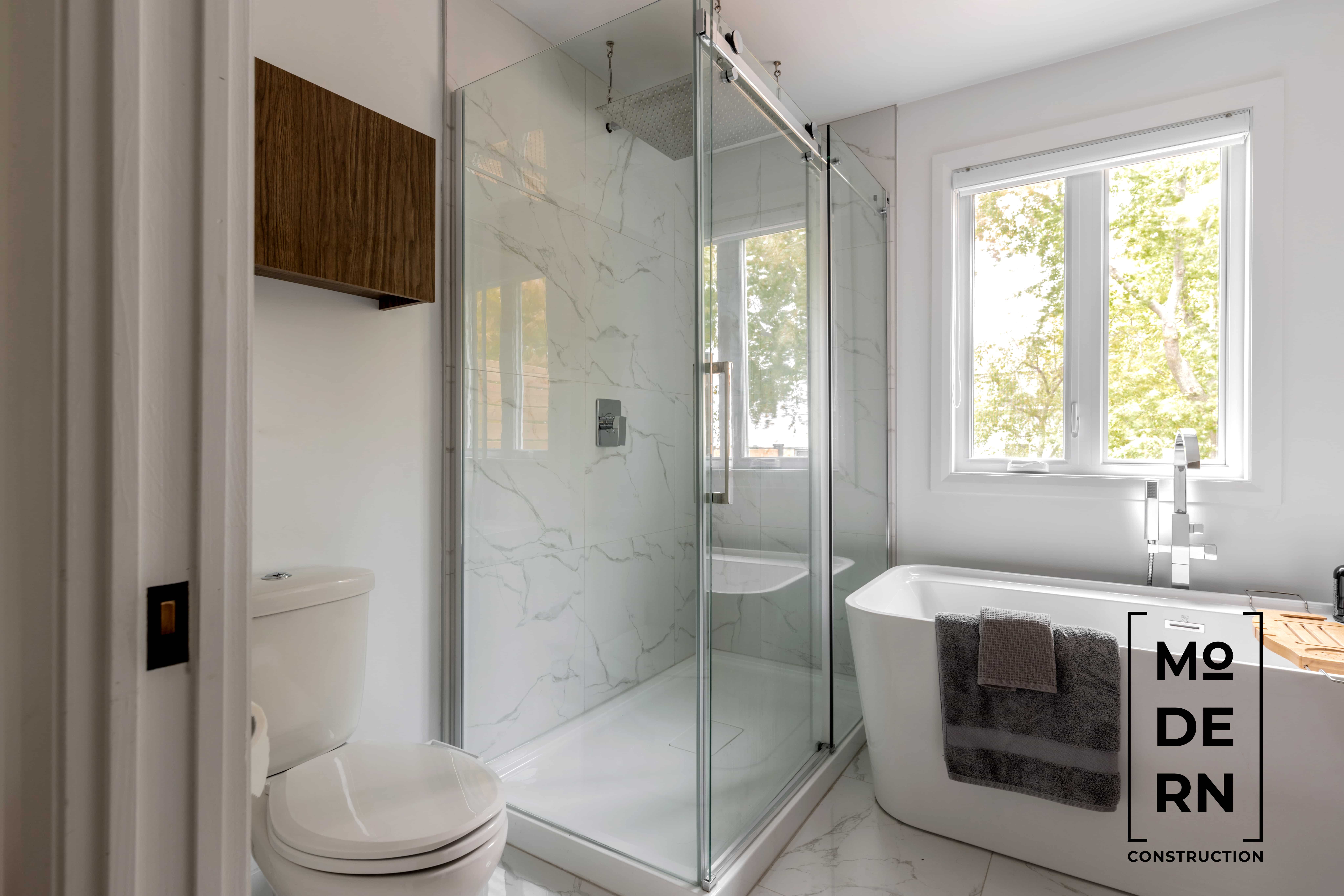 Salle de bain moderne avec douche et baignoire.