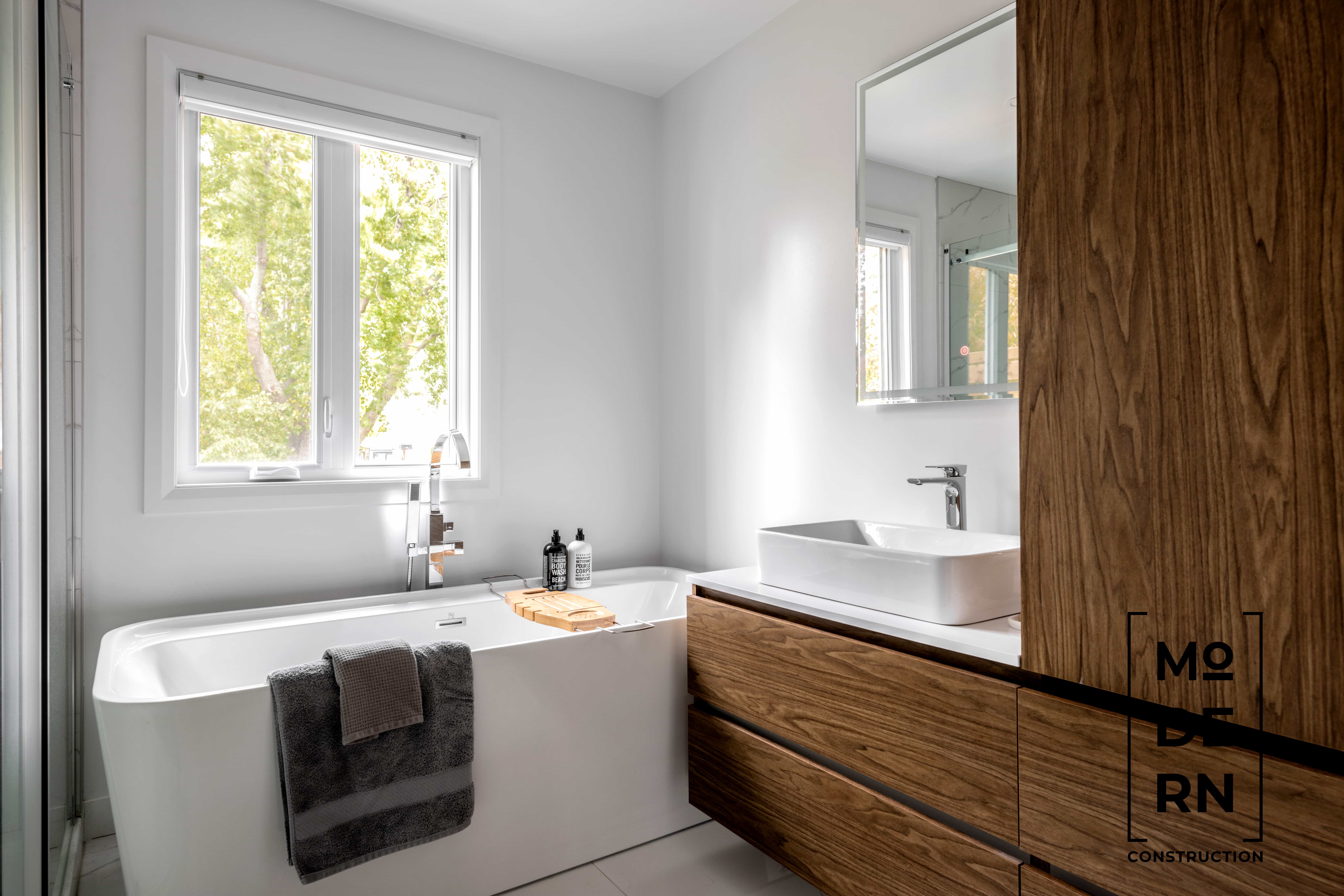 Salle de bain moderne avec baignoire et lavabo.