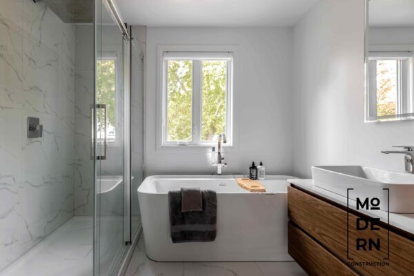 Salle de bain moderne avec baignoire et douche.