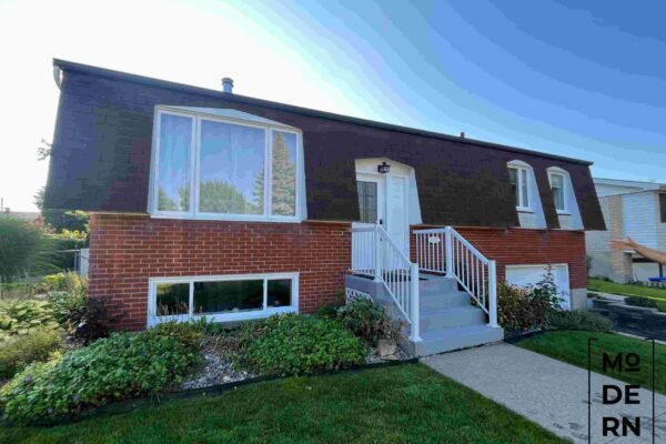 Maison moderne en briques avec escalier blanc.