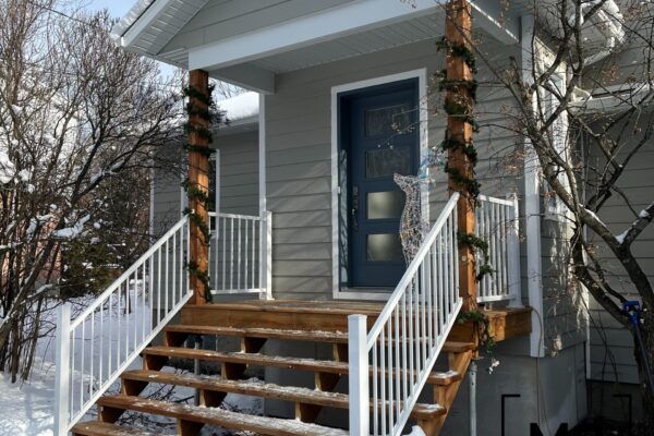 Entrée de maison avec neige sur les marches.