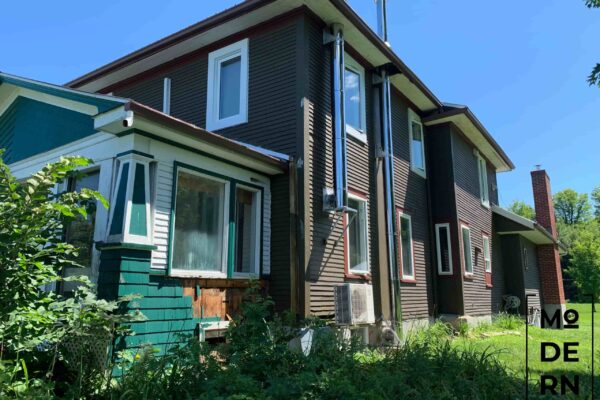 Maison moderne en bois avec cheminée rouge.