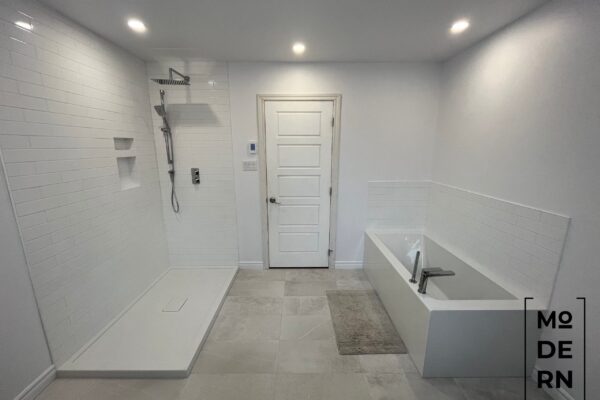 Salle de bain moderne avec douche et baignoire.