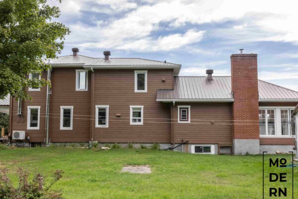 Maison moderne marron avec cheminée en briques.