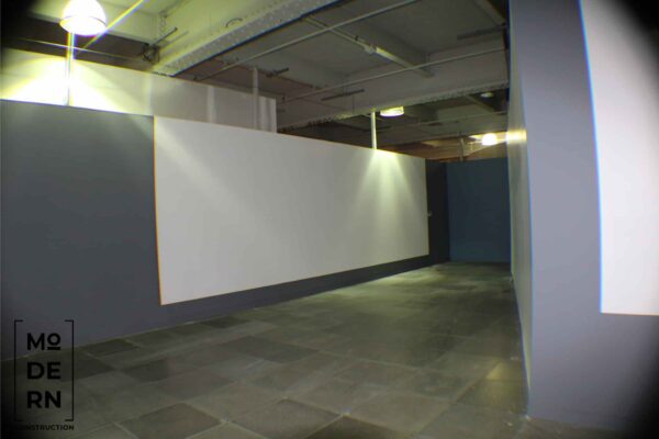 Couloir moderne avec murs et éclairage industriels.